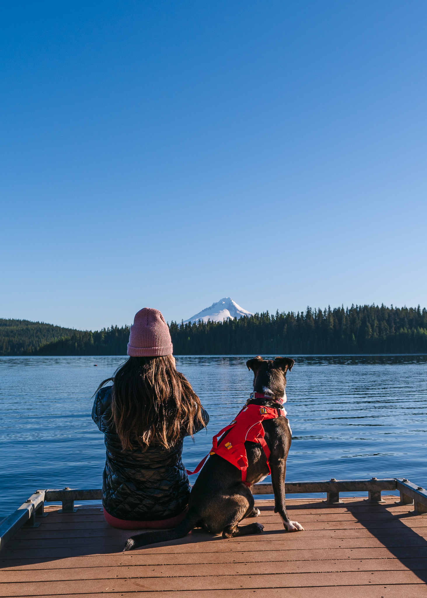 Mia and her dog looking at Mt. Hood from a dock on Timothy Lake.