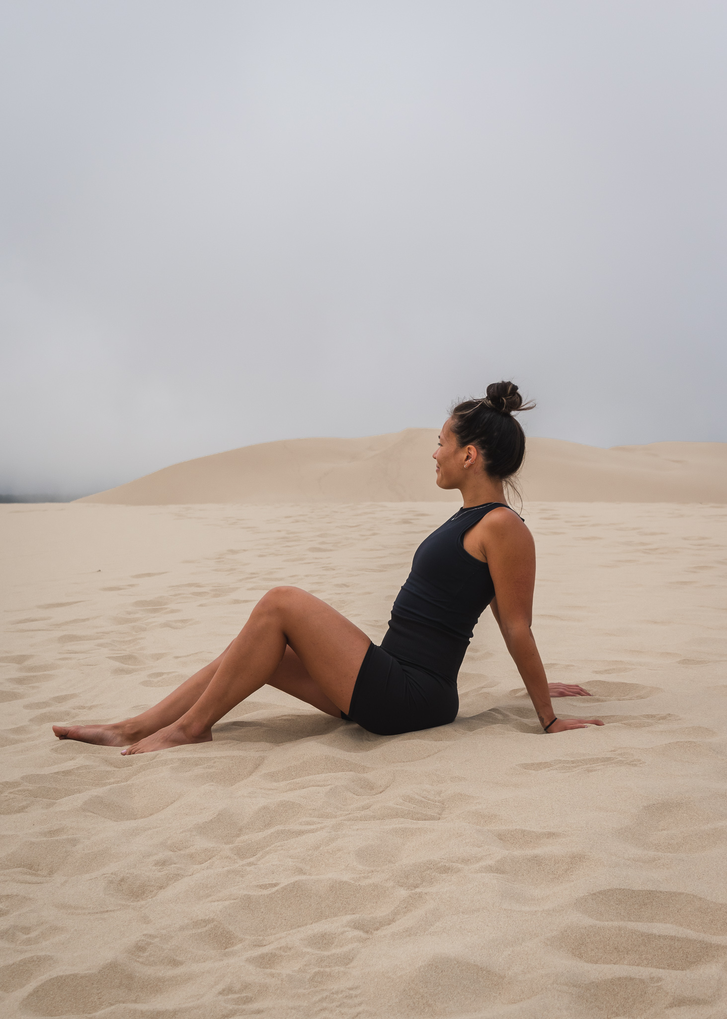 Mia sitting in the sand at the Oregon Sand Dunes