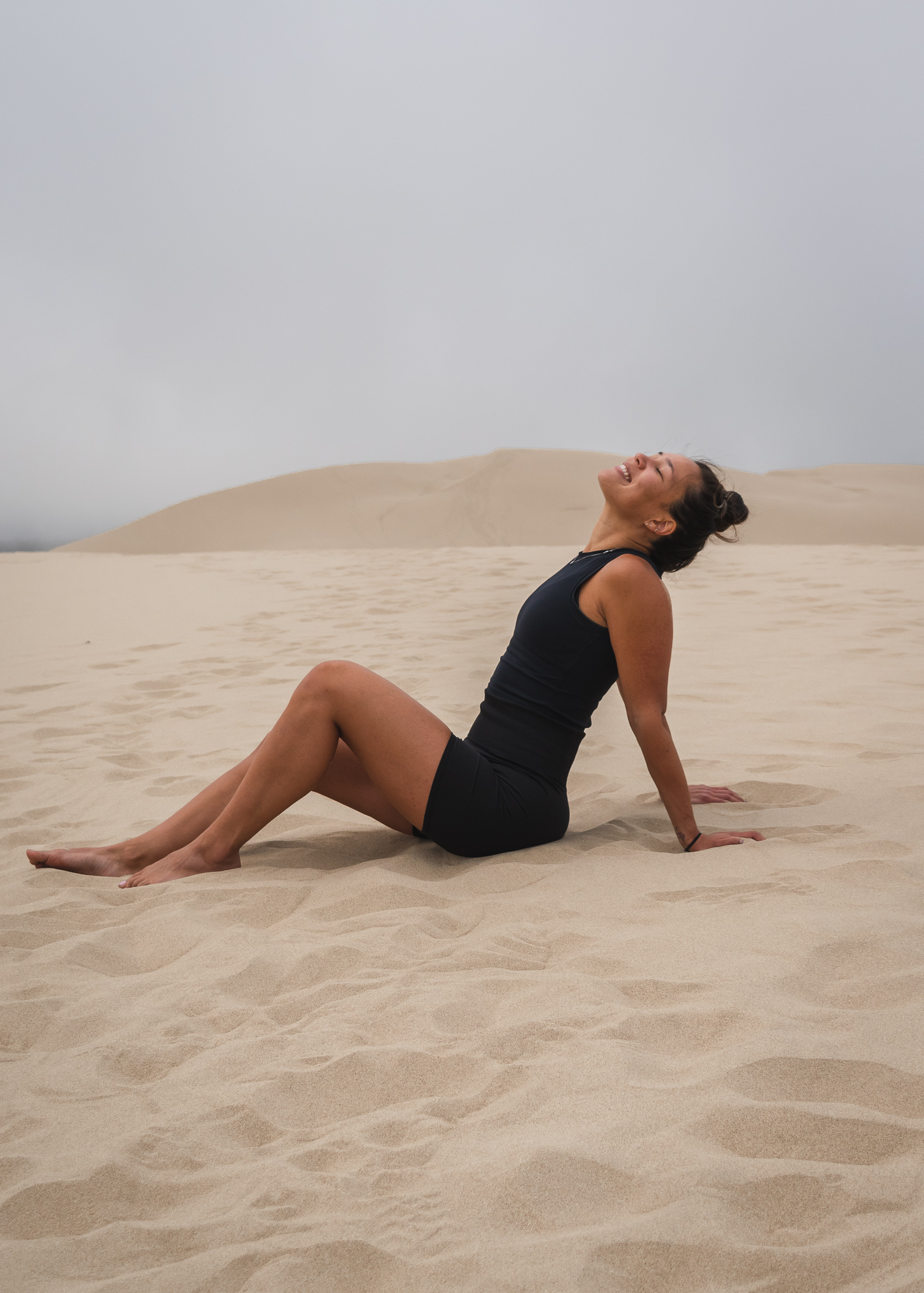 Mia sitting in the sand at the Oregon Sand Dunes