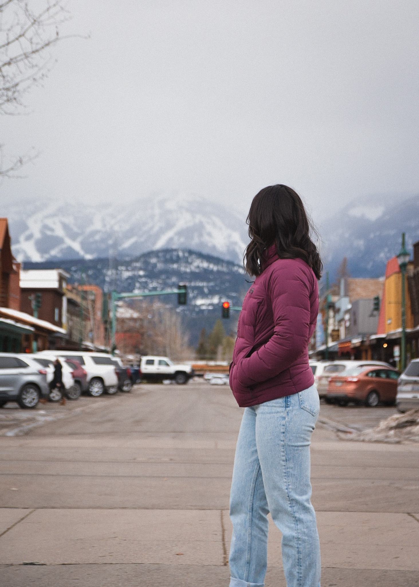 Mia standing in the street in Whitefish, Montana with a view of the mountains in the background