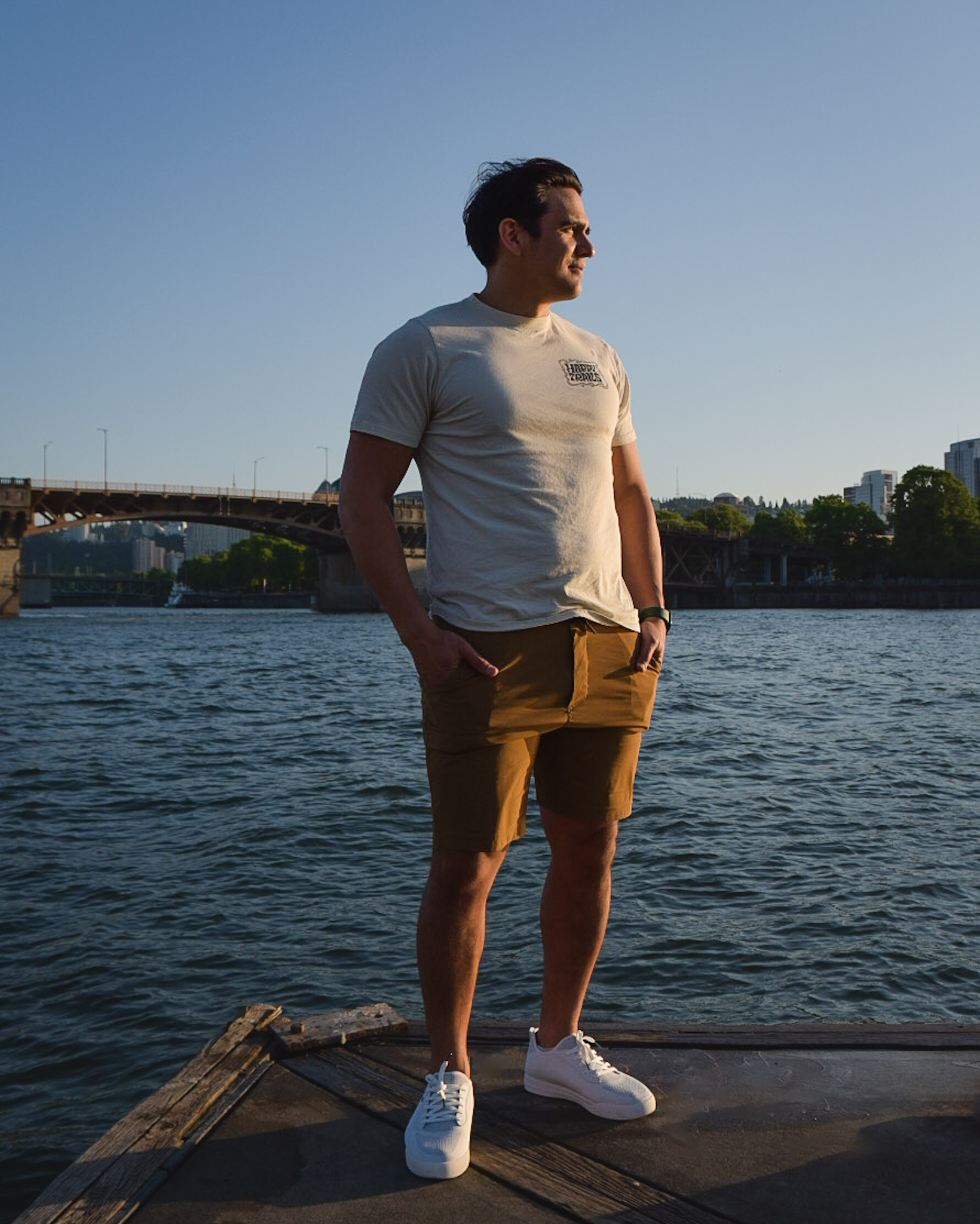 Jay standing on the Portland waterfront at sunset wearing waterproof white Vessi sneakers