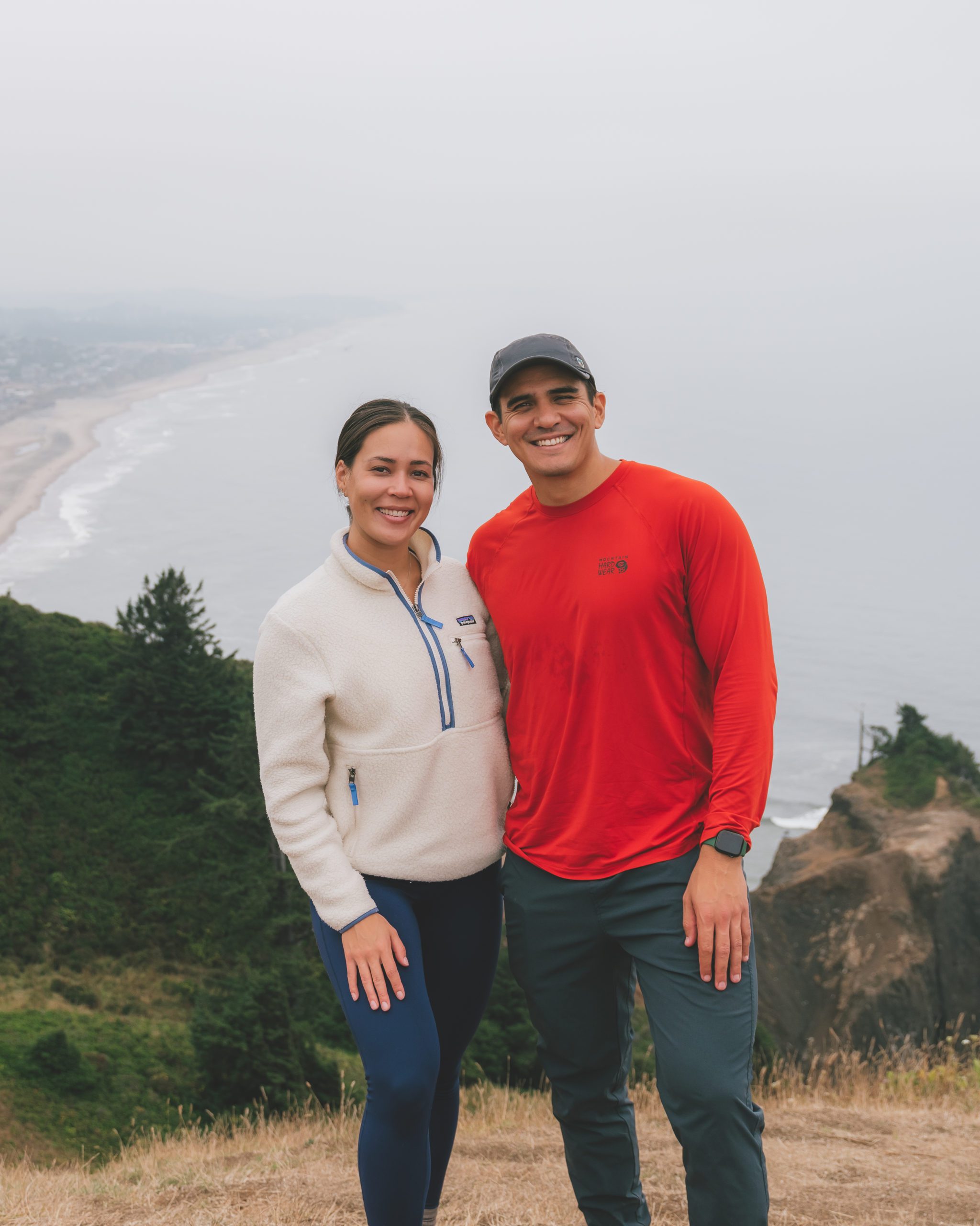 Mia and Jay, an adventure outdoor couple, at the top of the God's Thumb hike on the Oregon Coast.